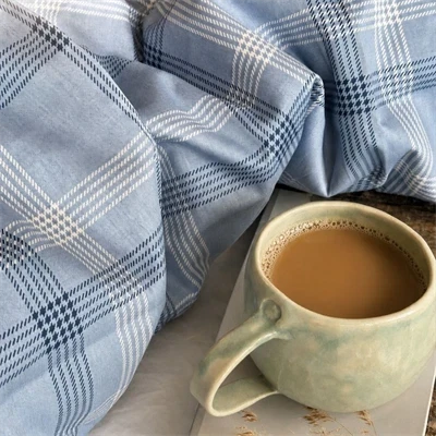 alvin sengetøj 140x200 blå tern med kaffe i seng