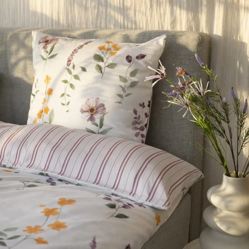 blomstret og stribet sengetøj rosa på redt seng